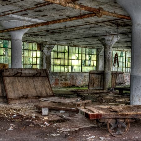 Abandoned Yorklyn Delaware Fiber Factory with dollies, concrete columns, rust, hanging ceiling lights and foliage stained windows.