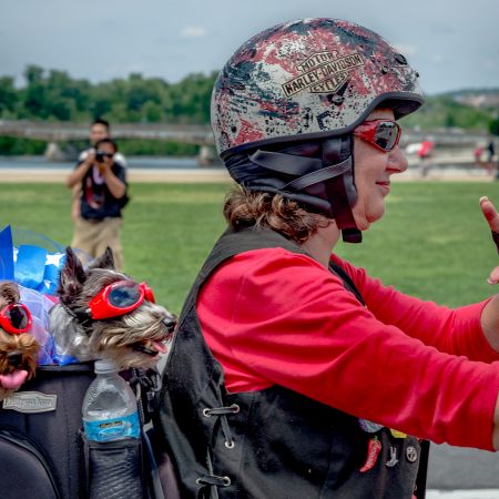 Women with two Yorkshire Terriers wearing goggles on Harley Motorcycle for Rolling Thunder event in Washington, D.C.