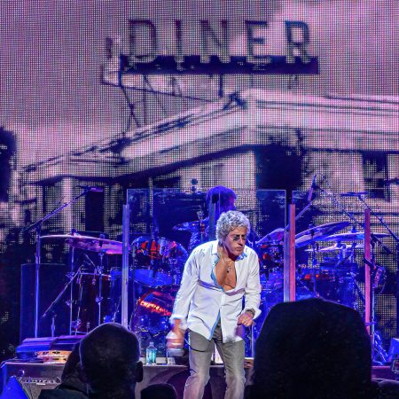 Roger Daltrey of The Who performs against a Diner motif background.
