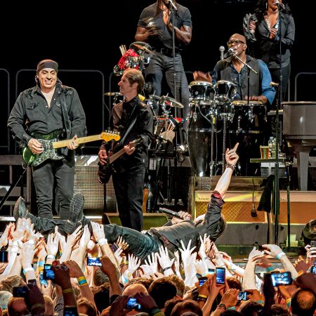 Bruce Springsteen body surfing in concert audience.