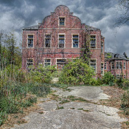 Abandoned Pennsylvania Pennhurst Asylum building with vines and broken windows.